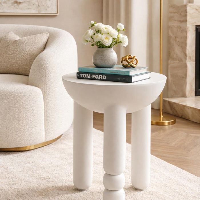 White side table with books and flowers in a living room setting