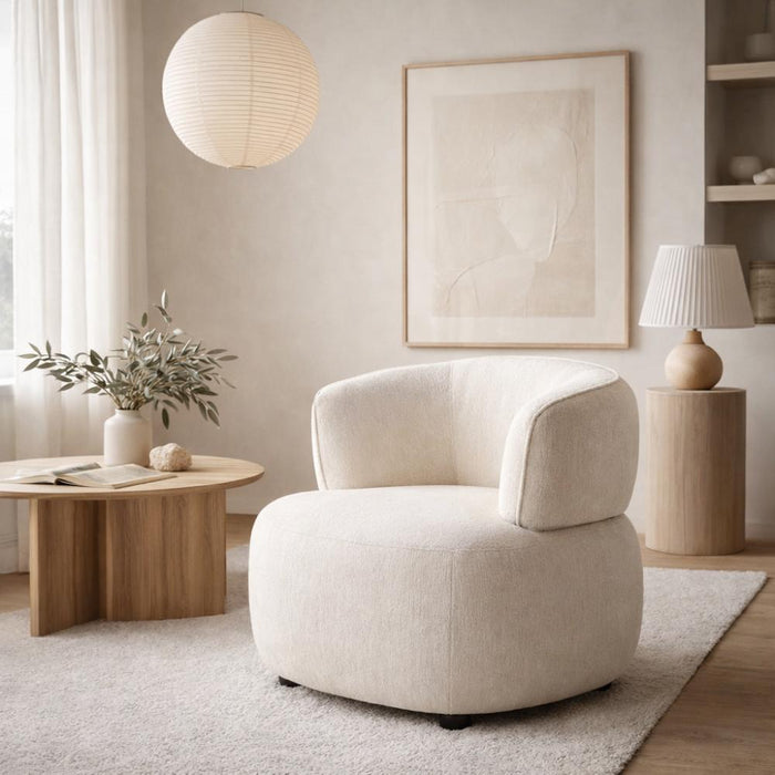 Modern living room with a beige armchair, wooden coffee table, and decorative elements.